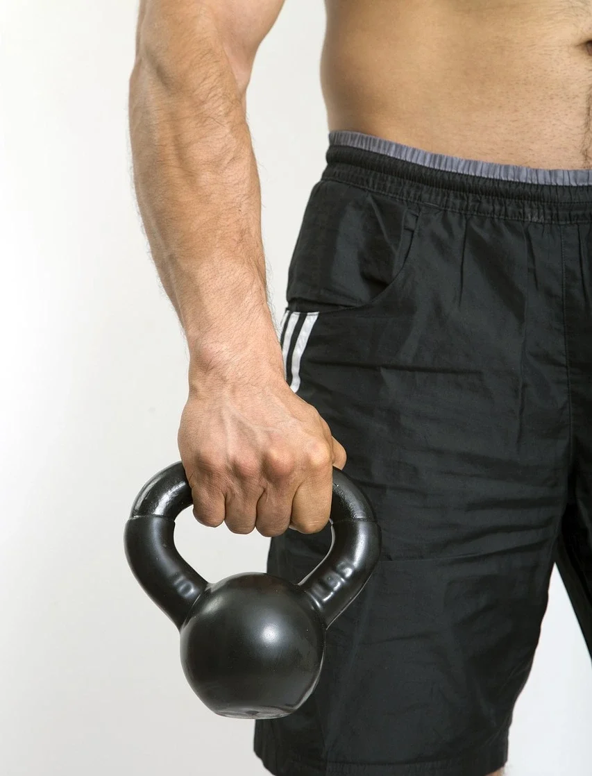 uomo con kettlebell in mano attrezzi home gym sardegna